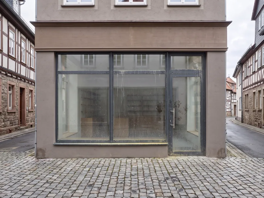 Schaufensterfront eines Ladengeschäfts vor der Reinigung, Glas mit Straßenstaub, Spritzern und Handabdrücken
